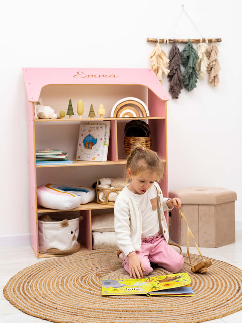 pink child-sized dolls house shaped bookcase