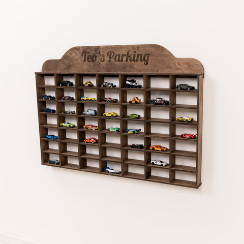Wooden toy car parking garage with 'Teo's Parking' on a white background